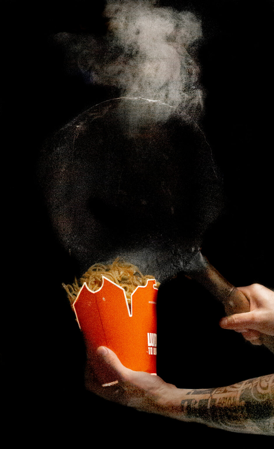 Un Cuisinier qui remplis une boite de nouille à emporter du Restaurant asiatique de street food Wok To Walk de Toulouse en France