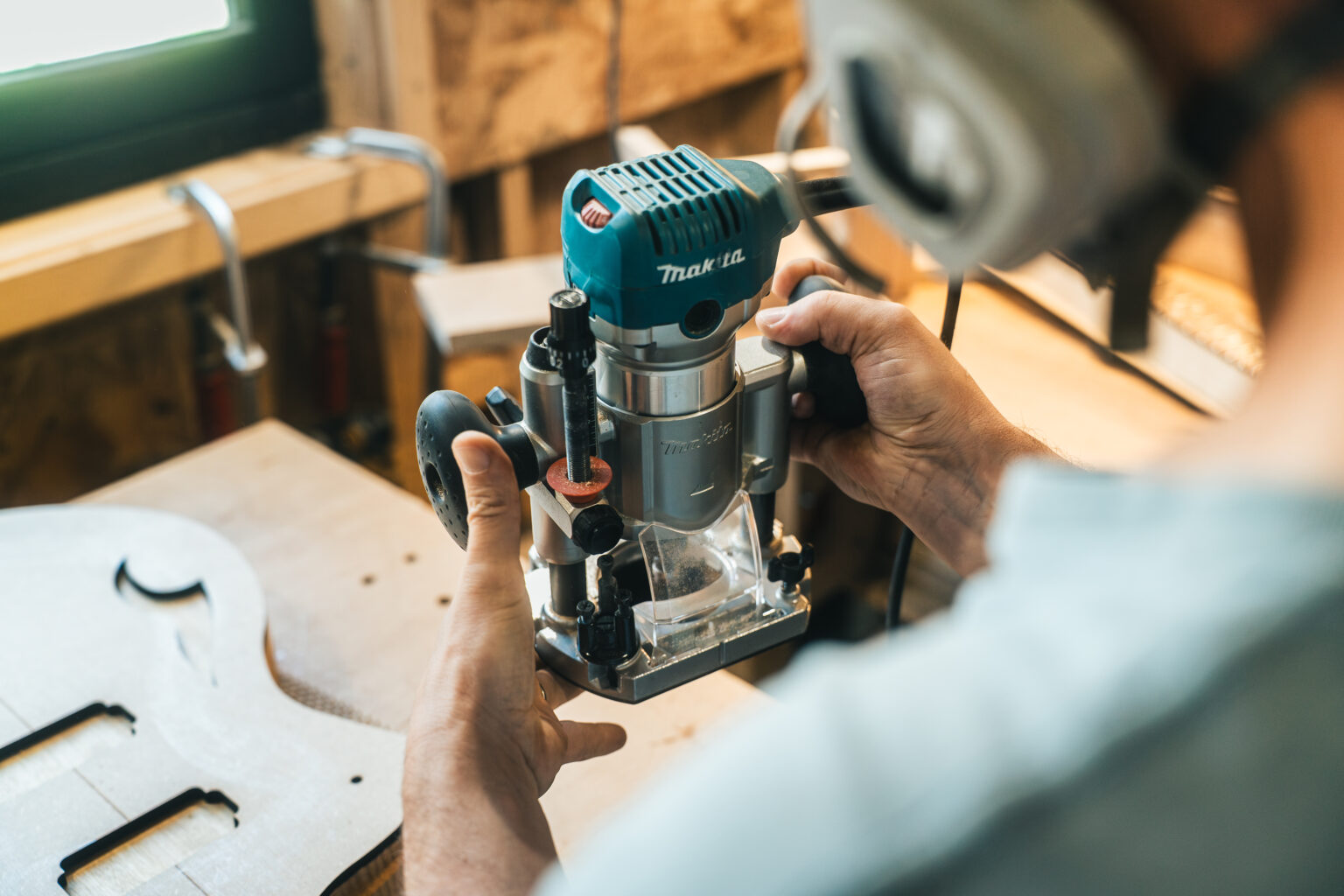 Un luthier préparant sa ponceuse pour une guitare